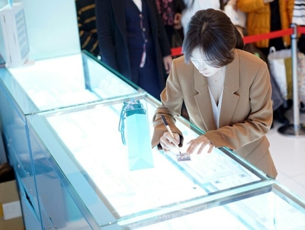 송하윤이 즉석에서 찍은 폴라로이드 사진에 사인을 하고 있다.