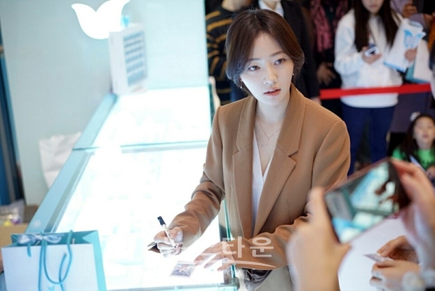 송하윤이 즉석에서 찍은 폴라로이드 사진에 사인을 하고 있다.
