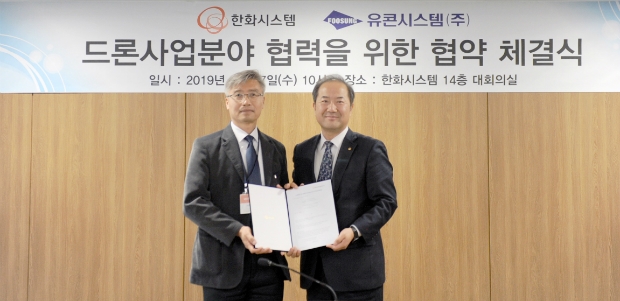 (왼쪽부터)유콘시스템 송재근 대표와 한화시스템 정석홍 사업본부장이 드론 및 무인기 분야 포괄적 업무 협력을 위한 양해각서를 체결하고 기념촬영을 하고 있다