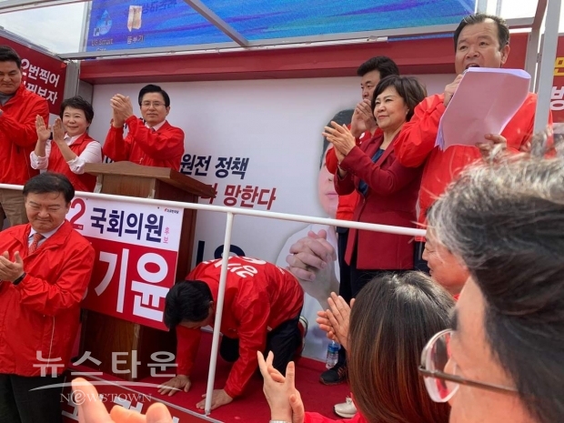 강기윤 후보가 출정식에서 지지자들에게 큰 절을 하고 있다.