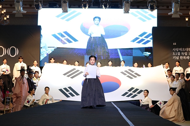 사이로 어린아이가 나와 독립선언문을 낭독하고 관객과 함께 기립하여 만세삼창을 하고 있다.
