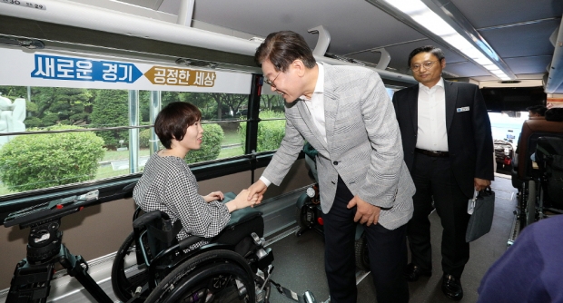 누림버스에서 장애인과 인사하는 이재명지사