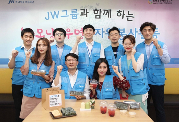 JW한마음봉사단원들이 단오 전통 음식을 만들고 기념촬영을 하고 있다