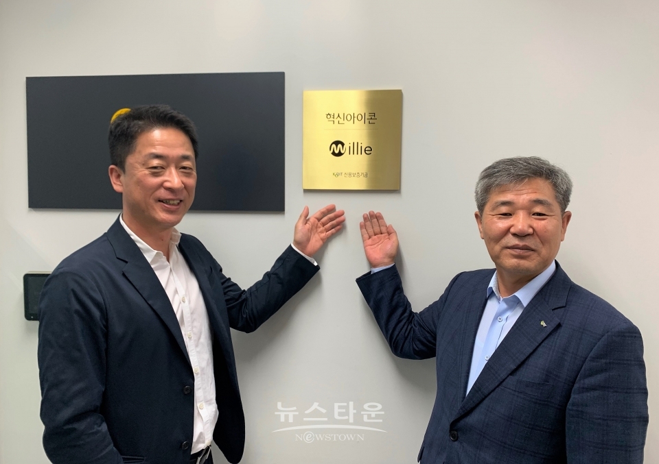 신용보증기금 혁신아이콘 1기 현판 앞에서 기념 촬영을 하고 있는 밀리의 서재 서영택 대표(왼쪽)과 조경식 신용보증기금 이사(오른쪽)