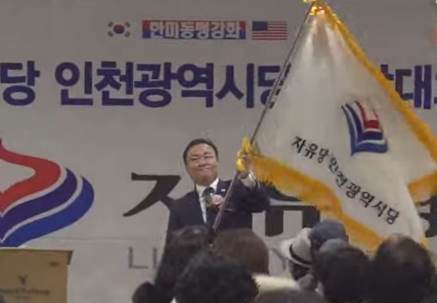 손상윤 자유당 창당준비위원장이 20일 당기 전달에 앞서 당기를 흔들고 있다.