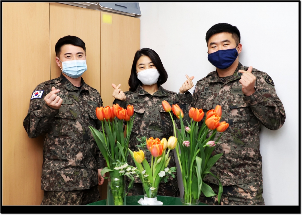 36사단 간부들이 지역 화훼농가를 돕기 위해 구매한 꽃을 사무실에 비치해 놓고 웃고 있다