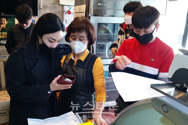 아산사랑상품권 가맹점 모집 서포터즈들이 모바일 아산사랑상품권에 대해 가맹점 점주에게 설명하고 있다.