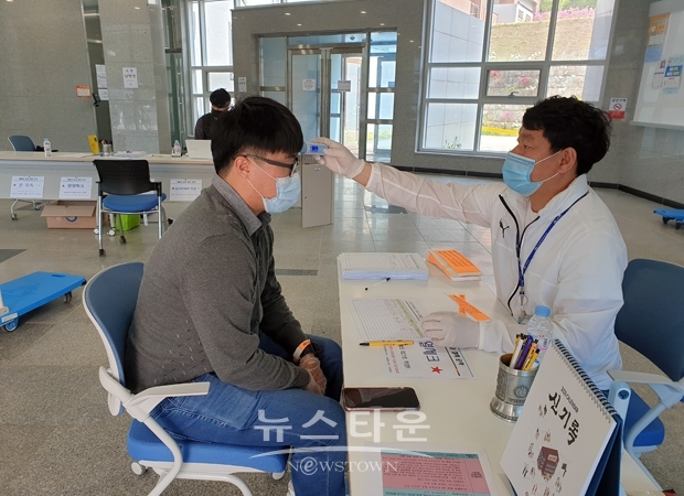 5월 4일 충남도립대학교 교직원들이 대면수업을 앞두고 비상방역 근무체제로 전환한 가운데 생활관을 방문한 학생의 체온을 체크하고 있다.