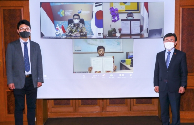 [대웅제약 사진자료] 전승호 대웅제약 대표(왼쪽)와 권덕철 보건복지부 장관이 화상연결로 인도네시아측 회담 참가자들과 기념사진을 촬영하고 있다.