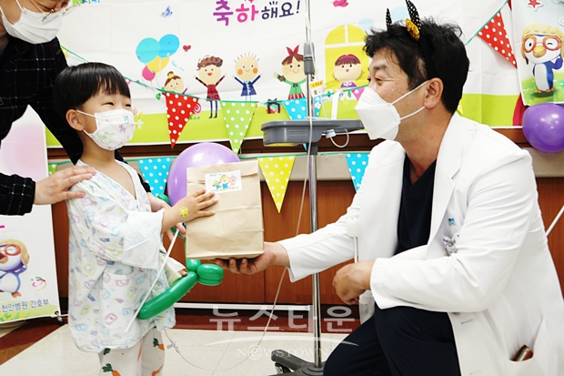 소아청소년과 김호 교수가 어린이에게 선물을 나눠주고 있는 모습