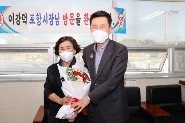 구룡포읍 최초로 선출된 여성 어촌계장 당선자에게 꽃을 전달하는 이강덕 시장