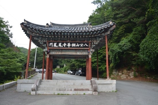 ▲ 동화사 봉황문(前정문) 안의 대형주차장은 하천부지를 성토 축척된 대표적 난개발, 산림훼손한 하천부지위에 대지로 위장된 부지위에 건립한 불법 건축물을 타인에게 임대해 무허가로 식당업을 영위 음식을 판매하고 관광객들에게 싸구려 중국산 물품 등을 판매하는 상점이 성업 중이다. 지자체의 철저한 단속과 원상복구와 철거가 시급하다.