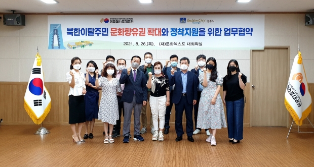 경주시와 (재)문화엑스포가 지역 내 거주 북한이탈주민들의 문화 향유 지원을 골자로 하는 업무협약을 체결하는 모습과 단체 사진촬영 모습