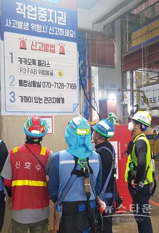 근로자들이 근로자 작업 중지권에 대한 안내문을 보고 있다