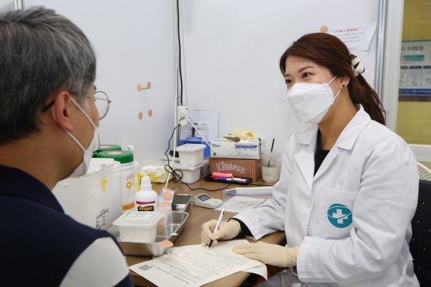경주실내체육관에 마련된 '코로나19' 예방접종센터에서 한 시민이 백신을 맞기 전 주의사항을 듣고 있다