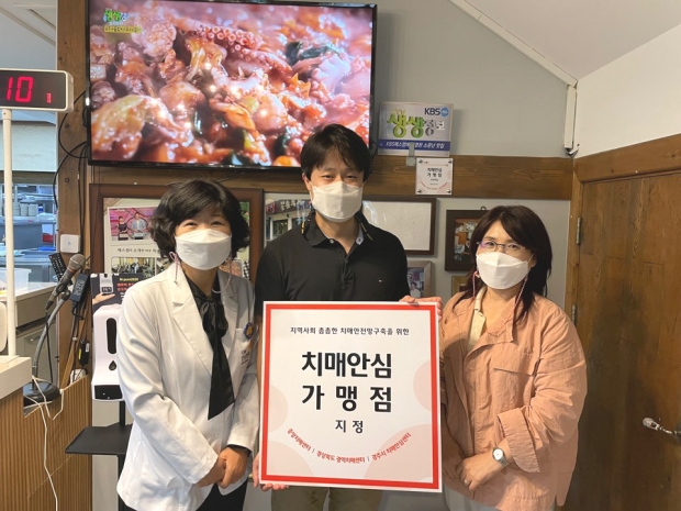 경주시 치매안심센터가 개인 사업장에 ‘치매안심가맹점’ 현판을 전달하며 기념촬영을 하고 있다