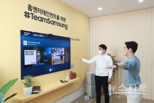 ▲ 서울 코엑스에서 열린 ‘KES 2021’ 삼성전자 부스에서 관람객이 Neo QLED 8K와 갤럭시 워치4로 삼성헬스 스마트 트레이너와 함께 맞춤형 홈트레이닝을 체험해보고 있다.(사진 : 삼성전자)
