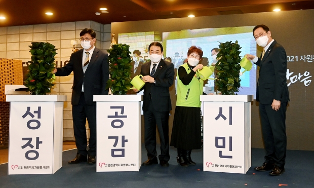 박남춘 인천광역시장이 지난 29일 남동구 샤펠드미앙에서 열린 '2021 자원봉사자의 날 기념 한마음&감사데이'에서 2만 시간 자원봉사자들과 세리머니를 하고 있다.