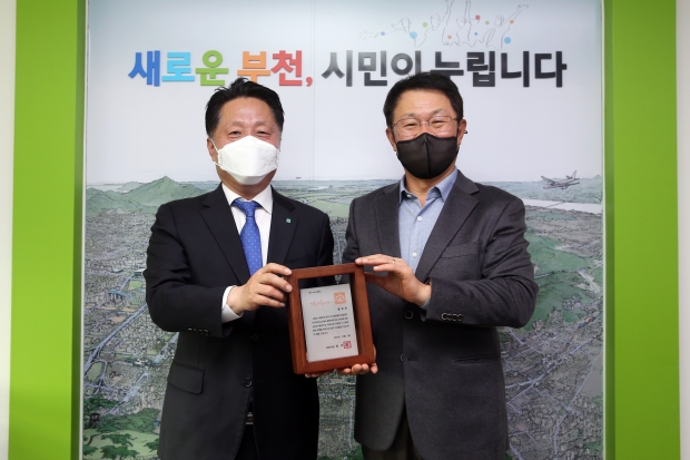 장덕천 부천시장(왼쪽)과 황희찬 선수의 아버지 황원경씨(오른쪽)가 감사패를 들고 기념촬영을 하고 있다