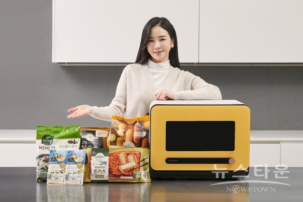 삼성전자 모델이 수원 영통구에 위치한 삼성전자 수원사업장에서 비스포크 큐커와 새롭게 협력하는 CJ의 다양한 간편식 제품을 소개하고 있다./사진 : 삼성전자