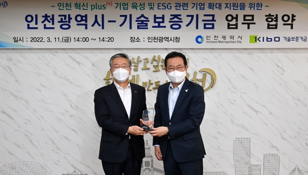 박남춘 인천광역시장이 지난 11일 시청 대접견실에서 열린 '인천광역시-기술보증기금 업무협약식'에서 김종호 기술보증기금 이사장과 서명한 협약서를 들고 기념촬영을 하고 있다.