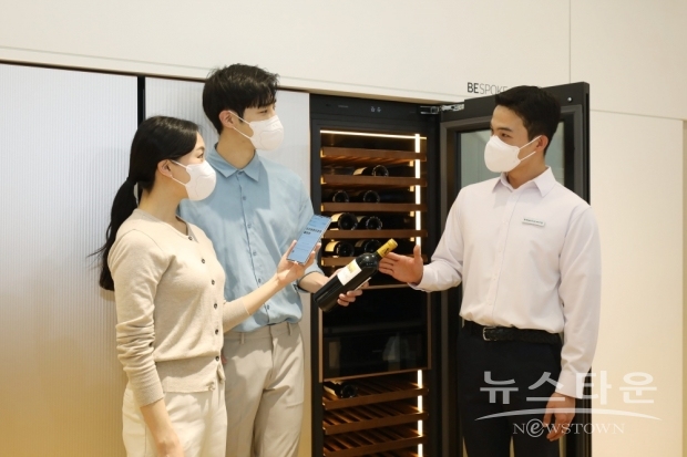 서울 코엑스에서 열린 ‘월드IT쇼 2022’ 삼성전자관에 마련된 팀삼성 홈의 프리미엄 키친에서 관람객이 ‘비스포크 와인냉장고 인피니트 라인’과 함께 와인 라벨을 스캔하면 와인 정보가 자동 입력되고 보관 리스트에 추가되어 편리한 관리가 가능한 스마트싱스(SmartThings)의 ‘소믈리에 앳 홈’ 기능을 체험하고 있다. /사진 : 삼성전자
