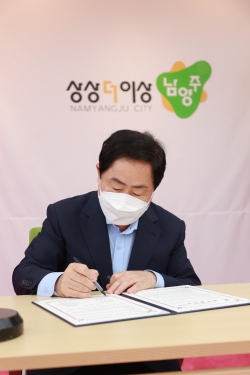 남양주시-중소벤처기업진흥공단 업무 협약서에 서명하고 있는 주광덕 남양주시장