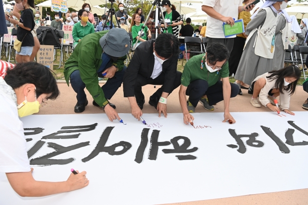 캘라그라피로 환경문구를 적고 있는 모습