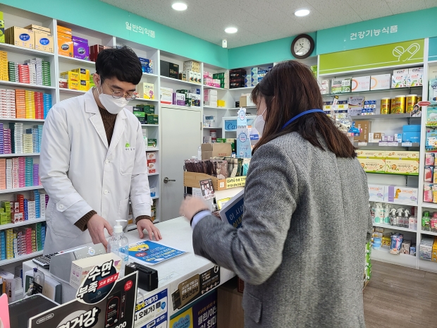경주보건소 직원이 지역의 한 약국을 방문해 실내마스크 착용 변경 지침을 설명하고 전단지를 배부하고 있다