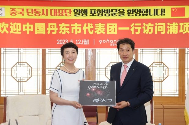 김남일 포항시 부시장이 12일 포항시청에서 장리홍 중국 단동시 인민정치협상회의 부주석에게 포항을 상징하는 기념품을 전달하고 있다.