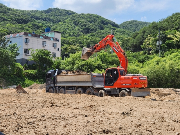 비포장비료를 부적정 살포한 비료 제조사업장이 지난 14일 장군면 금암리 소재 농경지에서 중장비를 동원해 문제가 된 비료를 수거하고 있다.