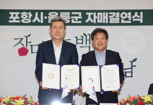 26일 포항시청 대회의실에서 열린 포항시와 울릉군의 자매결연식에서 (좌)이강덕 포항시장과 (우)남한권 울릉군수가 자매결연 협정서를 들고 있다.