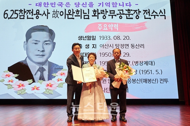 아산시가 8월 2일 시청 시민홀에서 6·25 참전 유공자 고(故) 이완희 병장의 배우자 서용화, 아들 이용득 씨에게 화랑무공훈장과 증서·기념패를 전달했다. 사진) 좌측부터 박경귀 아산시장, 고(故) 이완희 병장 배우자 서용화, 아들 이용득 씨