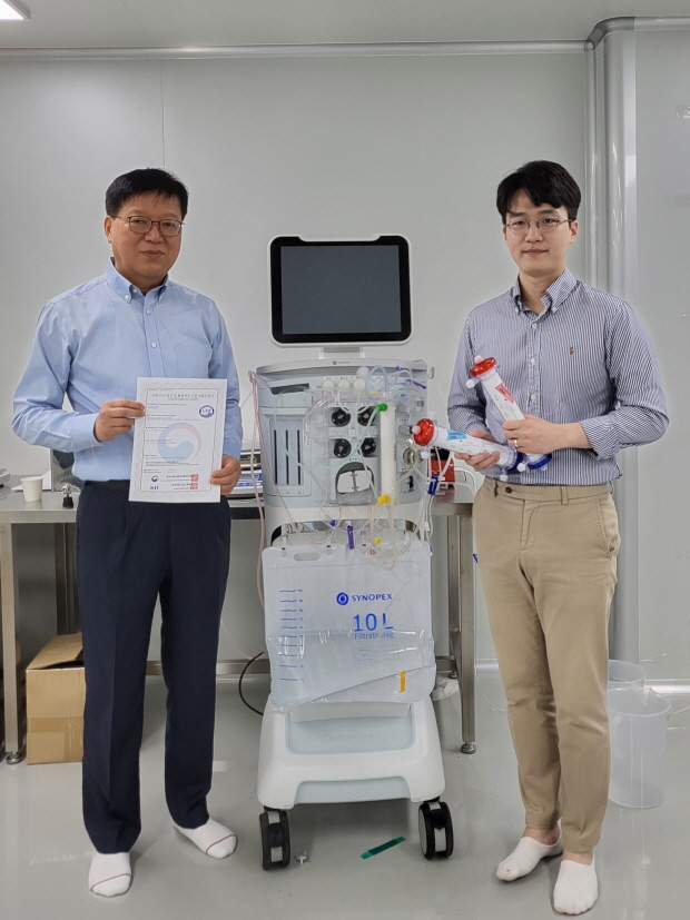 왼쪽 이진태본부장(박사)이 GMP인증서를 들고있는 모습, 오른쪽 이주신 박사