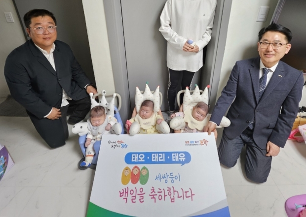최명환 복지국장(오른쪽)이 18일 백일을 맞은 세쌍둥이 가정을 방문해 축하했다