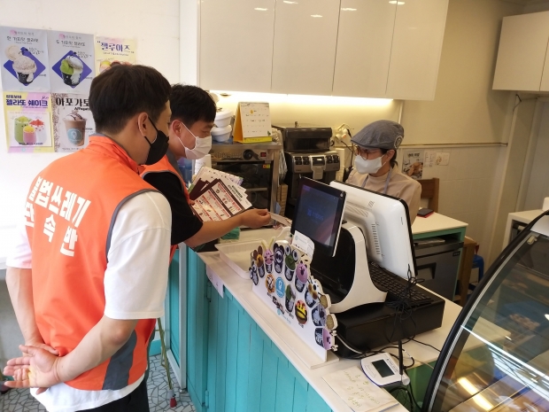환경미화원들이 관광지를 방문해 쓰레기 분리배출 및 적정처리에 대한 홍보물을 배부하고 있다.