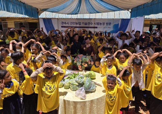 경주시 방문단이 캄보디아 선진농업 기술전수 시범농장을 방문해 현지 아이들과 기념촬영을 하고 있다.