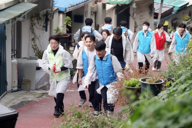 윤원석 IFEZ 청장이 참석자와 대화를 나누며 연탄을 나르고 있다.