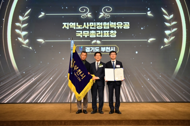 이재우 부천시 기획경제실장(오른쪽 첫번째)과 박종현 한국노총 부천·김포지역지부 의장이 김문수 고용노동부 장관에게 국무총리 표창을 받고 있다.
