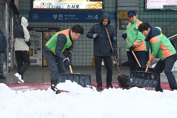 조용익 부천시장이 지난 11월, 부천역 마루광장에서 진행된 제설작업 현장을 찾아 폭설 대응 상황을 점검한 뒤 제설작업에 동참하고 있다.