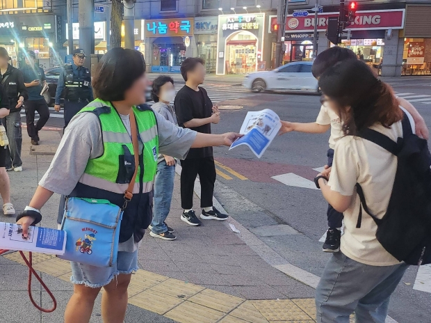 반려견순찰대가 시민들에게 반려동물 문화에 대한 홍보물을 나눠주고 있다.