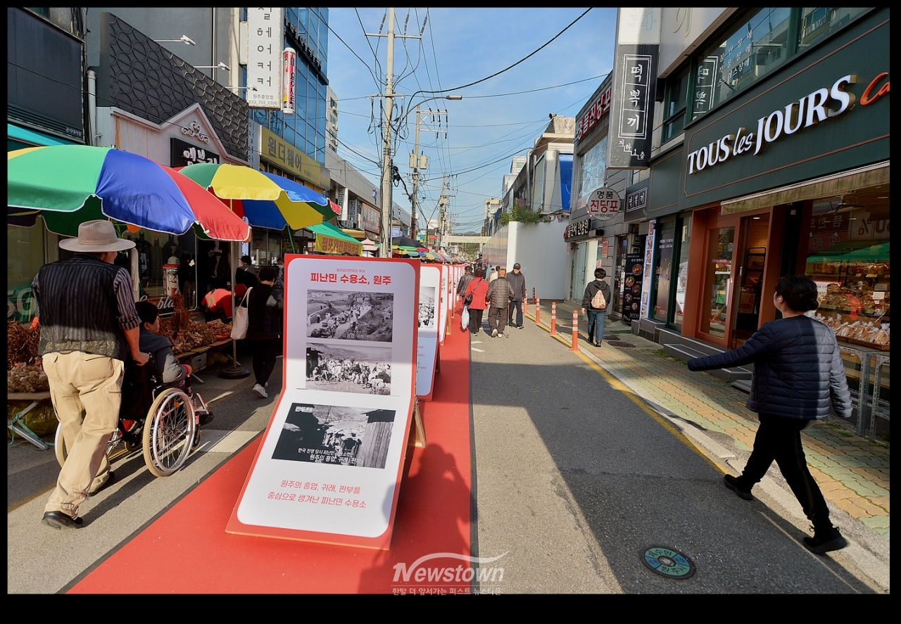 원일로와 중앙로를 통하는 골목길에 세워진 입간판 : "만두로드"라는 제목으로 만들어 졌는데 사진의 내용은 모두 6.25전쟁 당시의 사진으로 원주와는 무관한 사진들이다.