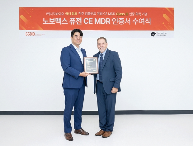 시지바이오 유현승 대표(왼쪽)와 빌 이노스(Bill Enos) BSI 글로벌 심사 총괄 디렉터가 ‘노보맥스 퓨전’ 유럽 CE MDR 인증서를 기념하며 촬영하고 있다.