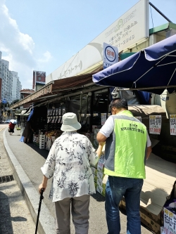 8월 조안면 봉사자가 고령 주민의 거동을 돕고 있다.<br>