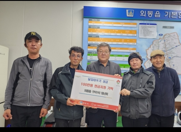 경주시 외동읍 구어1리 청년회 관계자들이 외동읍행정복지센터에서 달집태우기 행사 수익금 100만 원을 미혼모자 가족복지시설 누리영타운에 지정 기탁한 뒤 여동형 외동읍장(가운데)과 함께 기념촬영을 하고 있다.
