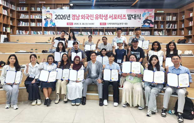 26일 경남도청에서 열린 ‘2026년 경남 외국인 유학생 서포터즈 발대식’에서 김성규 경남도 교육청년국장과 서포터즈들이 위촉장을 들고 기념촬영을 하고 있다./사진=경남도
