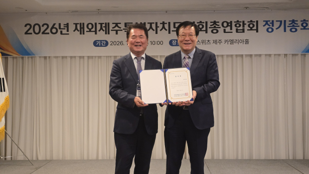 당선증을 전달받는 김상윤 회장(왼쪽)과 강명천 선거관리 위원장(오른쪽)